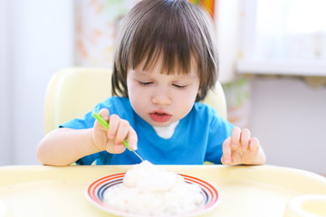 lovely toddler boy eating quark  with sour cream