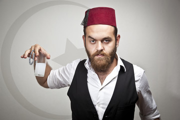 Man in traditional turkish hat dress kabadayi with alcohol raki