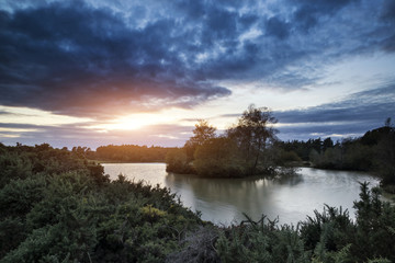 Beautiful Autumn sunset over lake landscape in forest