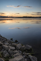 Fototapeta na wymiar Sunrise vibrant landscape of jetty on calm lake