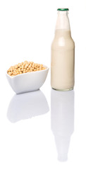 Soybean and bottles of soybean milk over white background