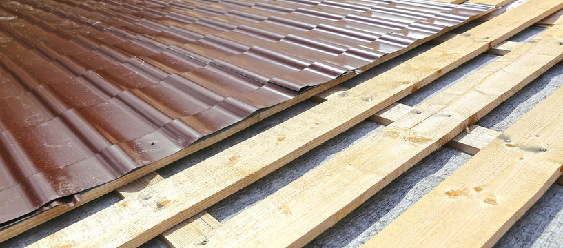 Covering the roof of a wooden house a metal tile