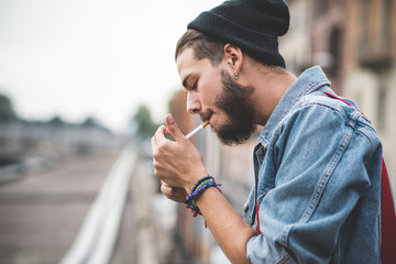 young handsome bearded hipster man smoking cigarette - Powered by Adobe
