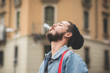 young handsome bearded hipster man smoking cigarette