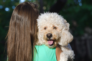 Young girl holding her dog on her shoulder