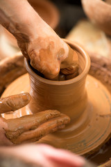 hands of a potter, creating an earthen jar