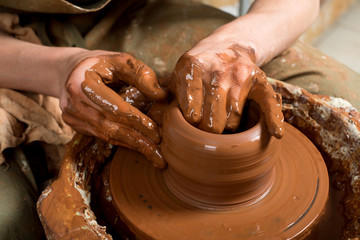 hands of a potter, creating an earthen jar