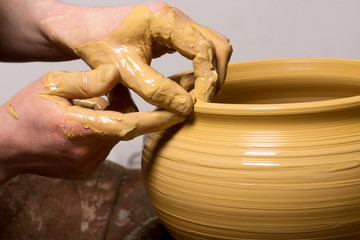 hands of a potter, creating an earthen jar