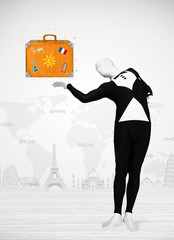 man in full body suit presenting vacation suitcase
