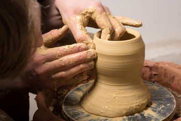 hands of a potter, creating an earthen jar