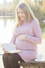 Obraz premium Pregnant woman on the autumn lake