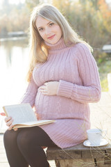 Obraz premium Pregnant woman on the autumn lake