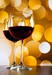 wine glasses on wood table on golden bokeh lights background