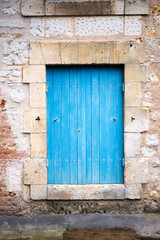 Fototapeta na wymiar House facade with blue shutters in France, Europe