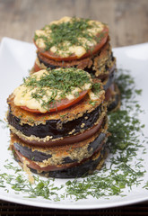 Roasted eggplant gratin with tomatoes layers, cheese and dill.