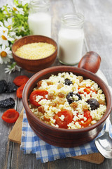Millet porridge with dried apricots and prunes in a bowl