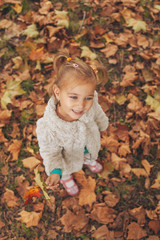 Cute little girl holding leaf in hand