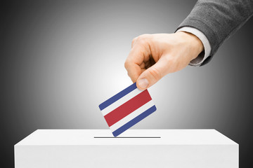 Male inserting flag into ballot box - Costa Rica