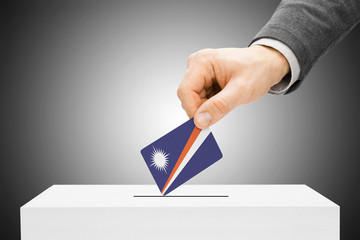 Male inserting flag into ballot box - Marshall Islands