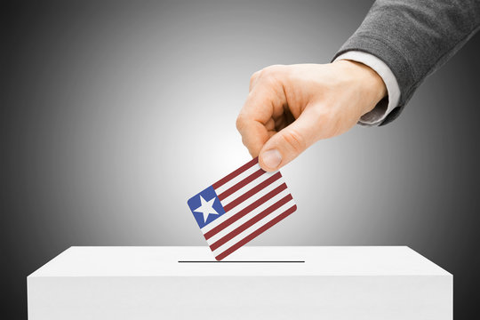 Voting concept - Male inserting flag into ballot box - Liberia