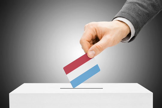 Male inserting flag into ballot box - Luxembourg