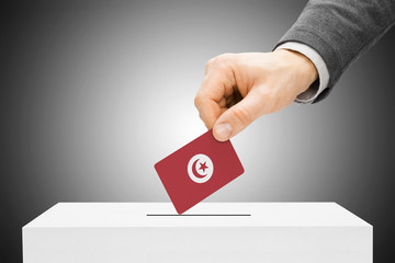 Voting concept - Male inserting flag into ballot box - Tunisia