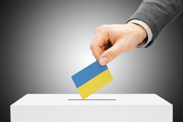 Voting concept - Male inserting flag into ballot box - Ukraine