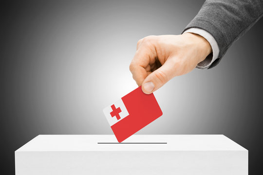 Voting concept - Male inserting flag into ballot box - Tonga