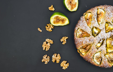 Fig cake with fresh figs and walnuts on black