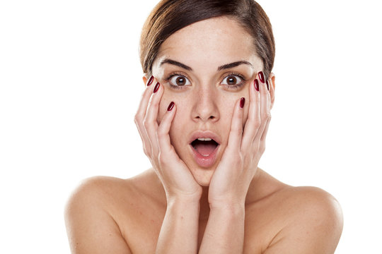 shocked young woman without make-up on a white background