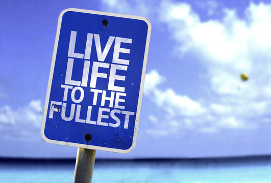 Live Life to the Fullest sign with a beach on background