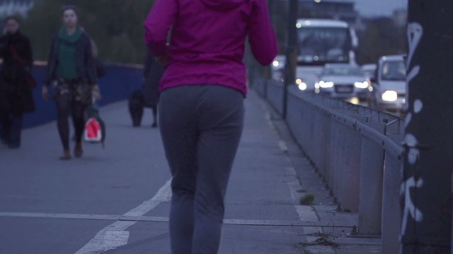 Woman jogging by the street in city, super slow motion, 240fps