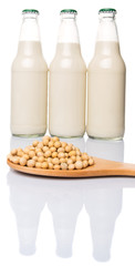 Soybean on wooden spoon and bottle of soybean milk drinks