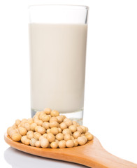 Soybean in a white bowl and a glass of soybean milk over white 