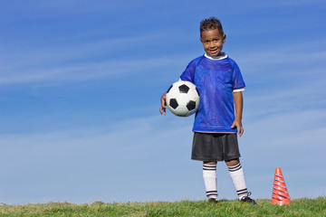 Cute Young Soccer Player holding a ball