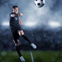 Soccer player kicking ball in a large stadium
