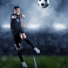 Glasschilderij Voetbal Soccer player kicking ball in a large stadium