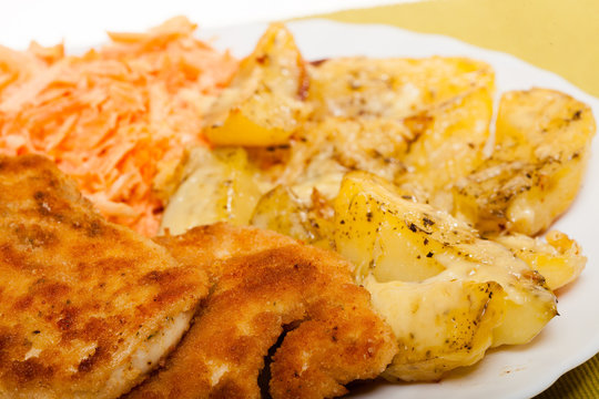 Dinner meal. Fried chicken roasted potatos and carrot salad.