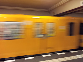 Fahrende Berliner U-Bahn in einem Bahnhof.