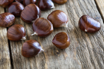 Raw chestnuts on wooden board