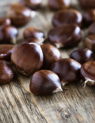 Raw chestnuts on wooden board