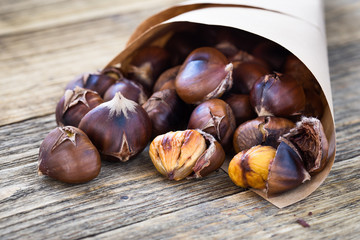 Delicious roasted chestnuts on wooden board