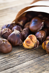 Delicious roasted chestnuts on wooden board