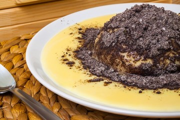 Fresh dumpling with vanilla sauce and poppy, close view
