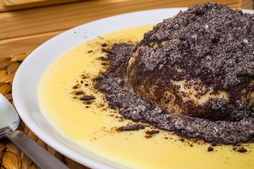 Fresh dumpling with vanilla sauce and poppy, close view