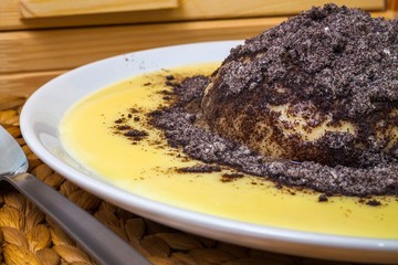 Fresh dumpling with vanilla sauce and poppy, close view
