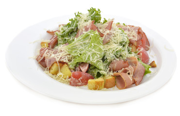Salad with bacon and croutons on white plate isolated