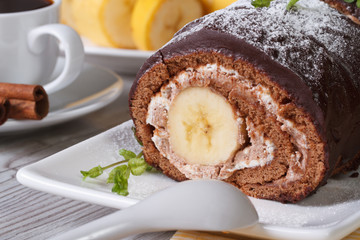 Chocolate roll with a delicate cream and banana closeup