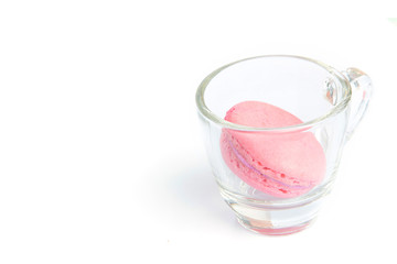 Pink french macarons in the cup on white background