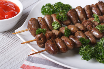 Chicken hearts grilled on skewers with parsley closeup